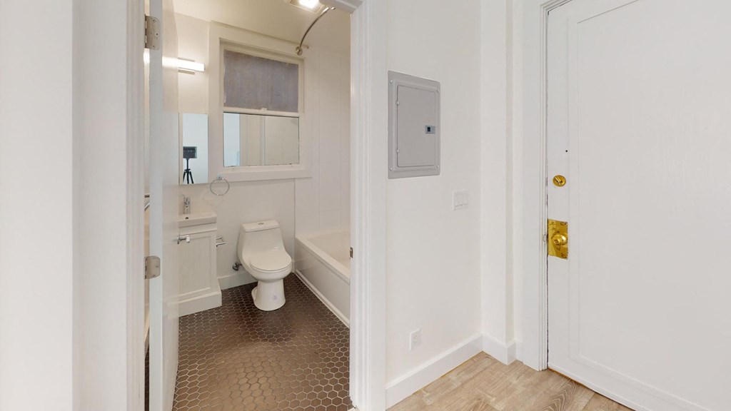 a bathroom with a toilet and a tub and a door