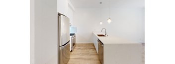 a renovated kitchen with white cabinets and stainless steel appliances