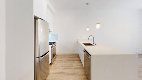 a renovated kitchen with white cabinets and stainless steel appliances