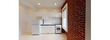 a kitchen with a brick wall and white appliances