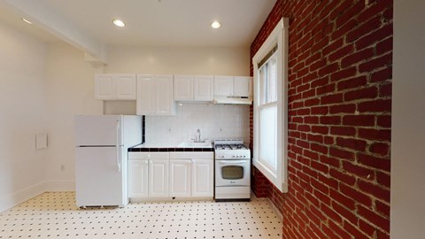 a kitchen with a brick wall and white appliances