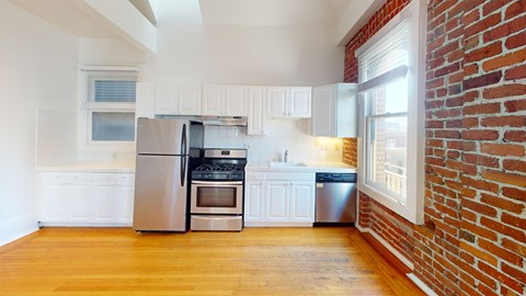 A kitchen with a stainless steel refrigerator and oven.