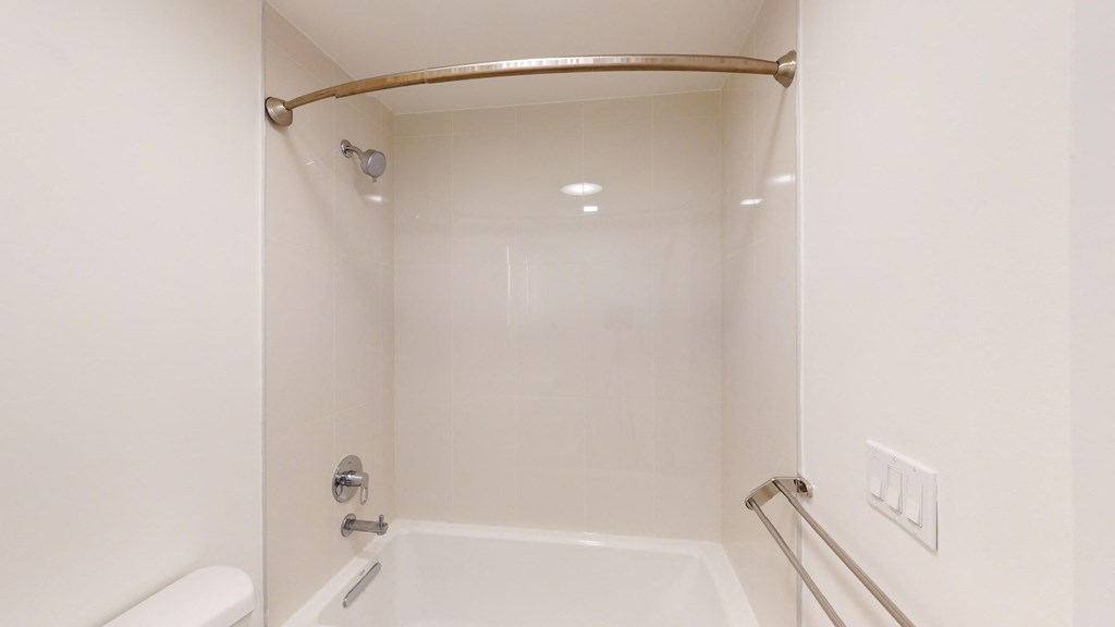 a white bathroom with a shower and a tub