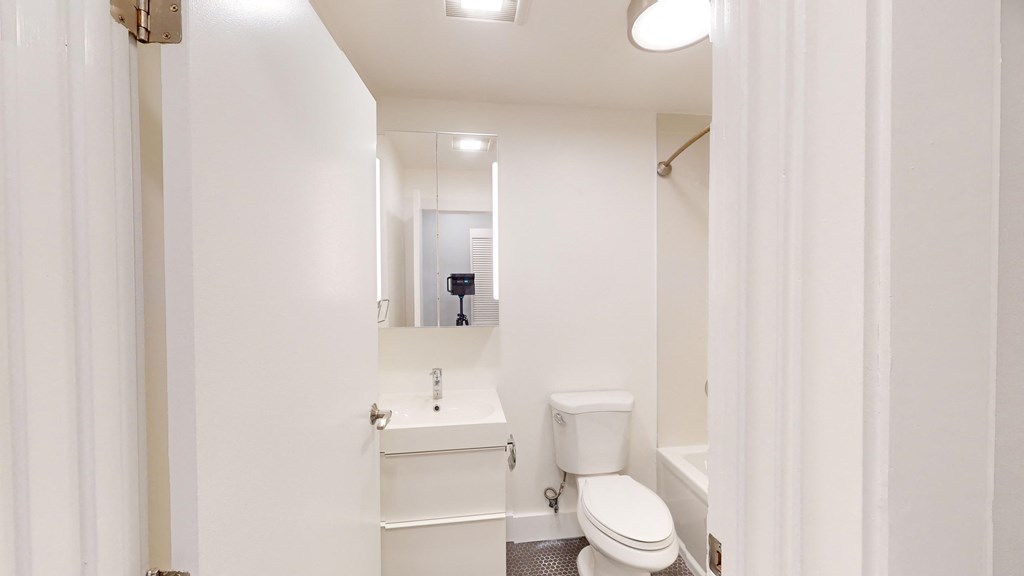 a bathroom with a toilet and a sink and a mirror
