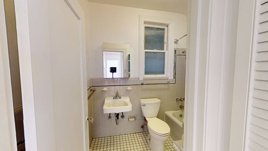 a bathroom with a toilet and a sink and a window