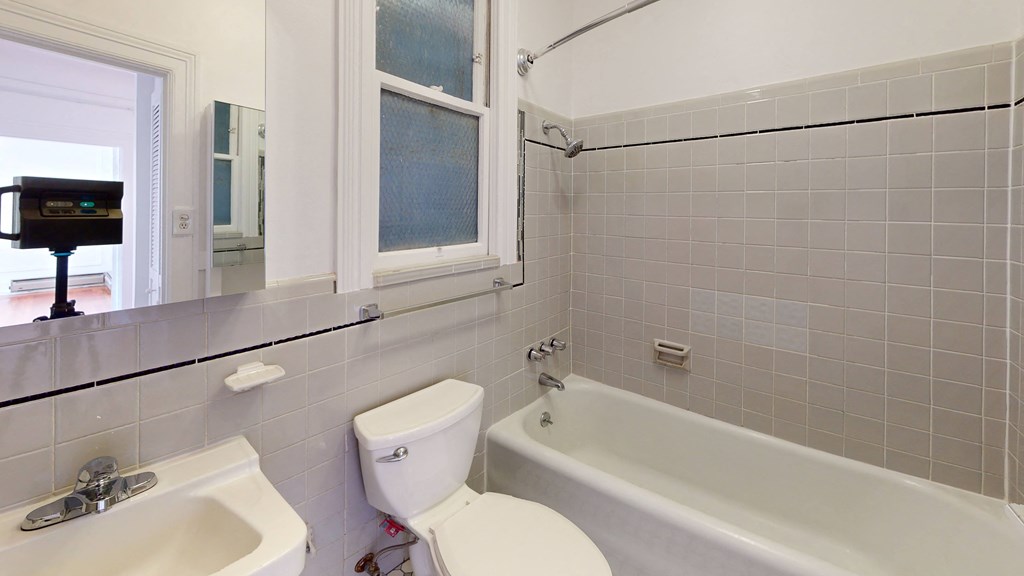 a bathroom with a toilet and a tub and a sink