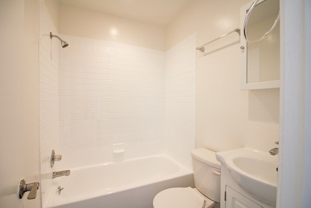 a bathroom with a toilet and a tub and a sink