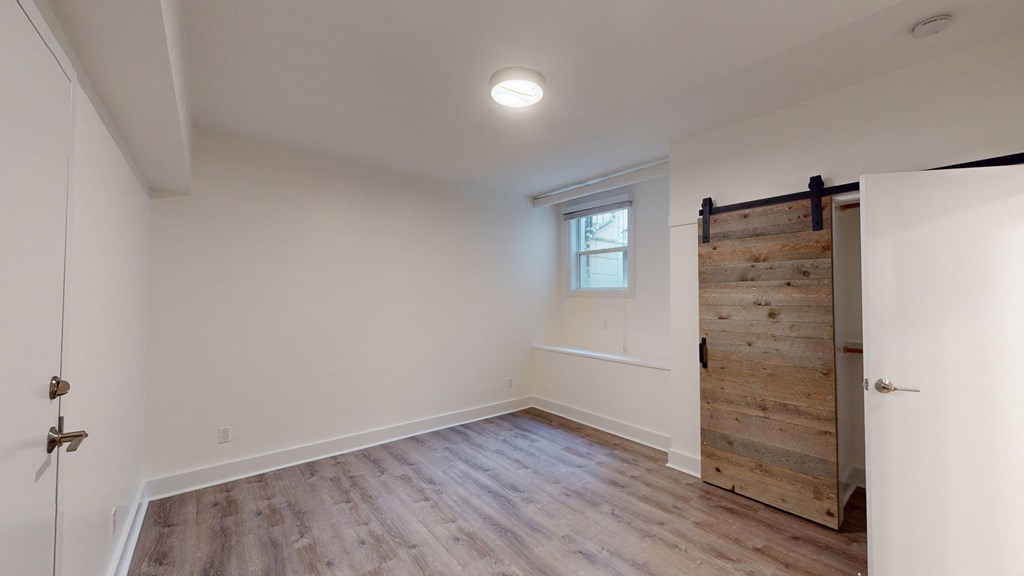 a bedroom with white walls and a sliding barn door