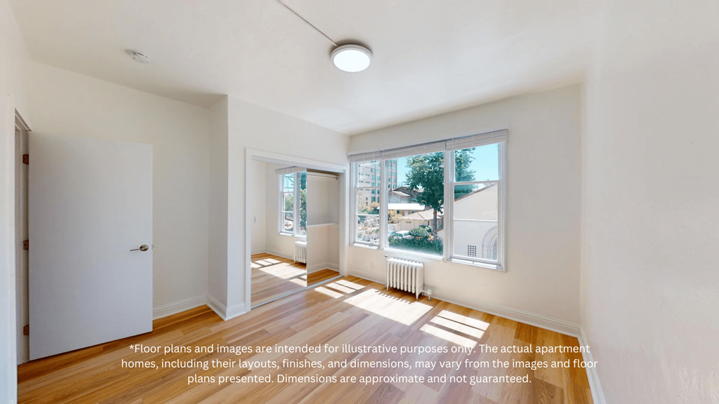 a living room with a large window and wooden floors
