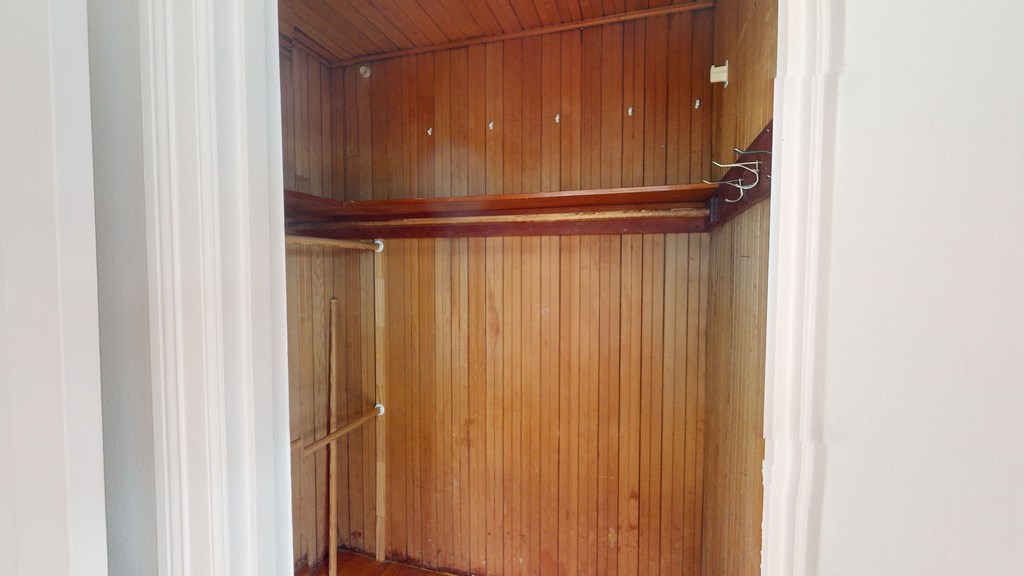 a closet with wood paneling and a white door