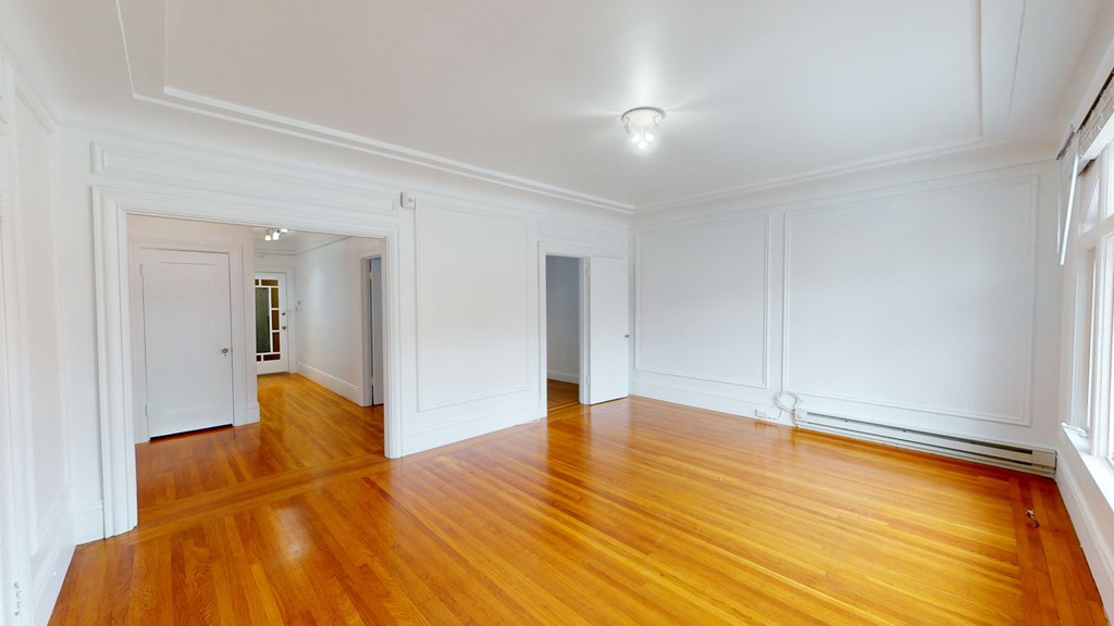 a living room with a hard wood floor and white walls