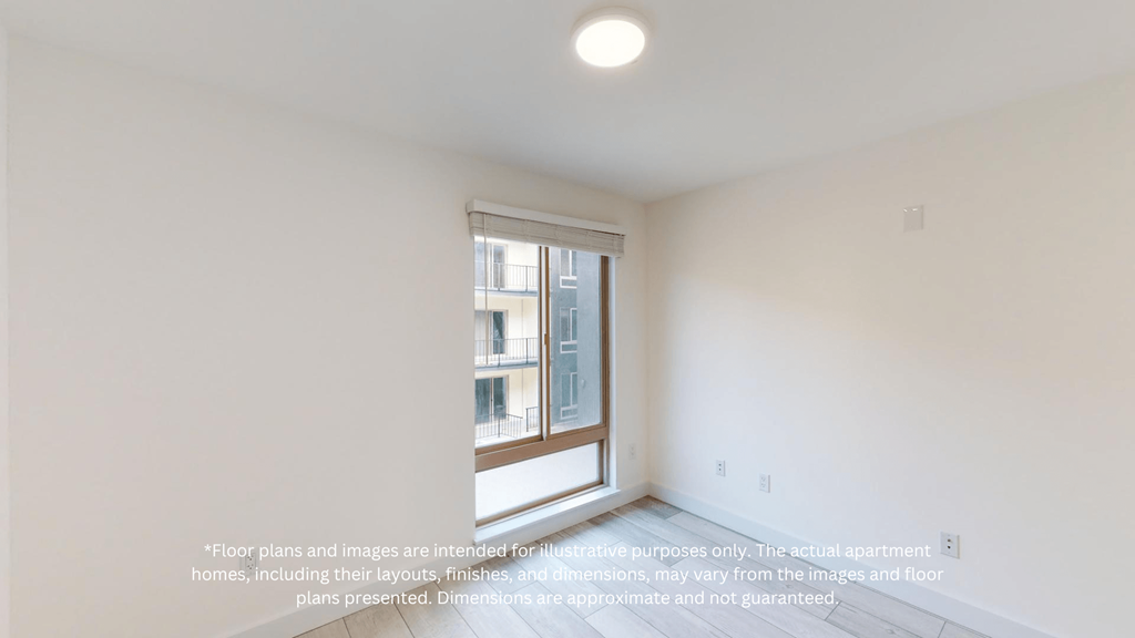 an empty room with a window and white walls