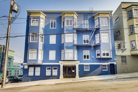 a blue apartment building on a city street