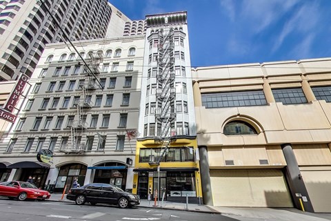 A tall building with a yellow and black structure in front of it.