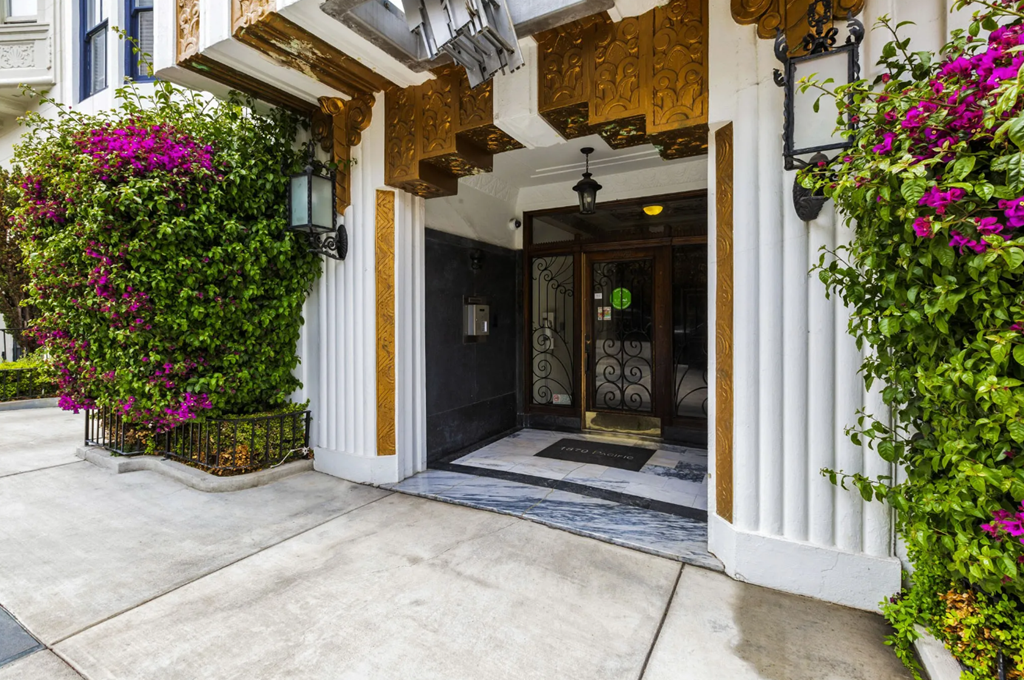 a view of the front door of a building with flowers