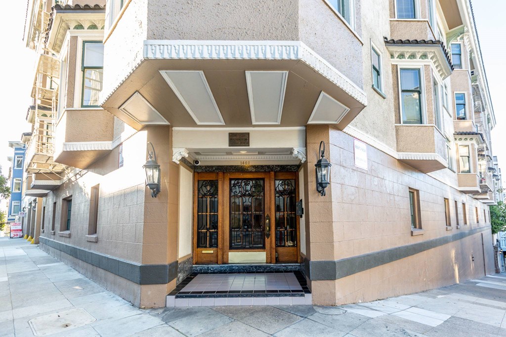 A building with a tan facade and a large wooden door.