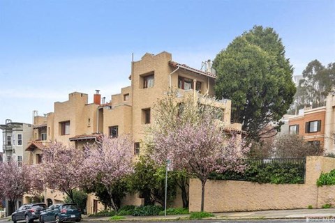 an apartment building with cars parked in front of it