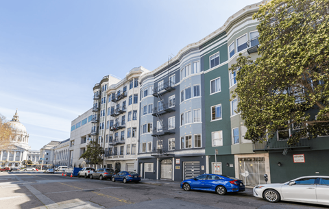 A street view of a residential area with cars parked on the side of the road.