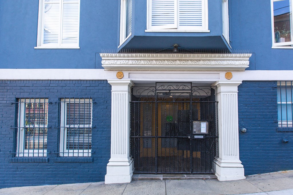 a blue building with a wrought iron gate in front of it