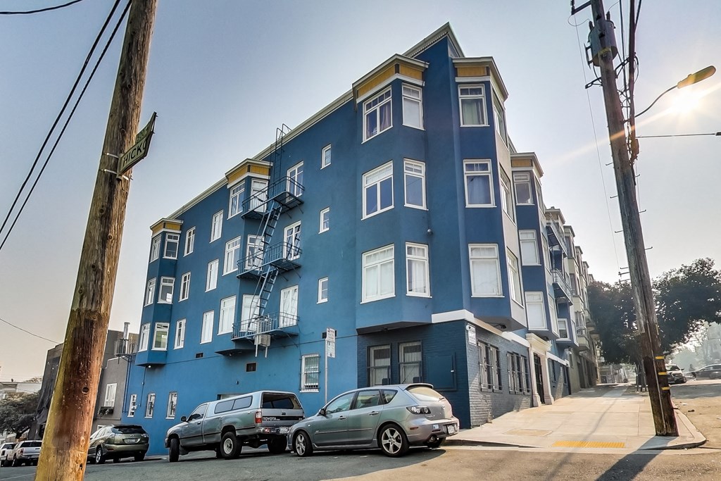 a blue building with cars parked in front of it on a street