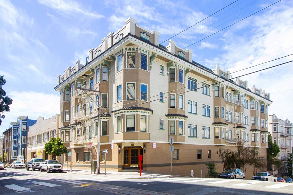 A large, multi-story building with a beige facade and blue trim.