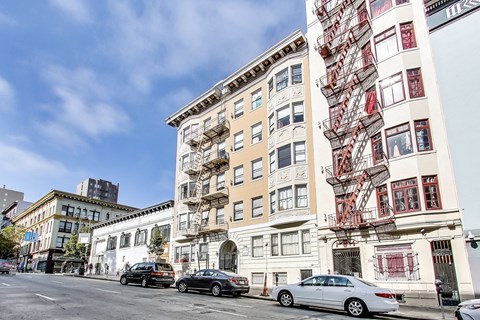 A white building with a red fire escape on the side.