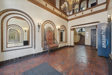 Ornate interior with tiled floor, decorative arches, mirrors, large chair, staircase, Amazon Hub