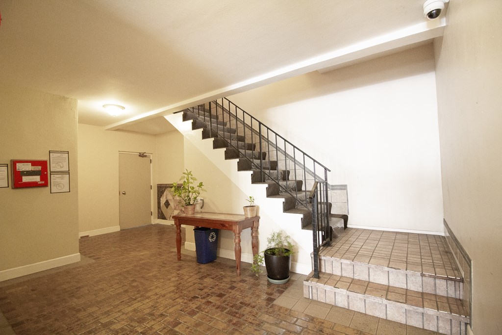 A staircase with a metal railing and a plant on the landing.