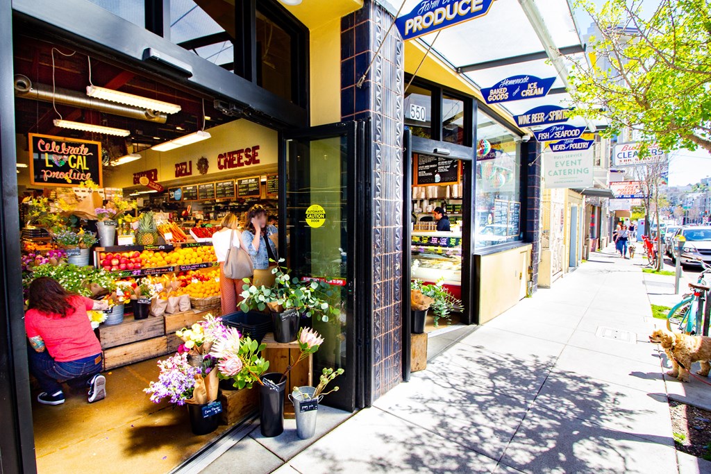 a flower shop on a sidewalk in front of a grocery store