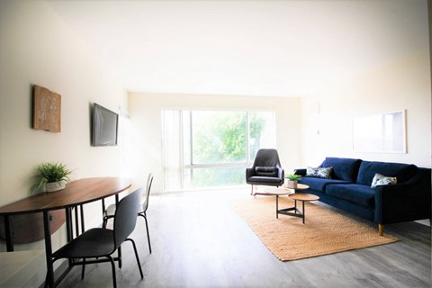 a living room with a blue couch and a dining room table