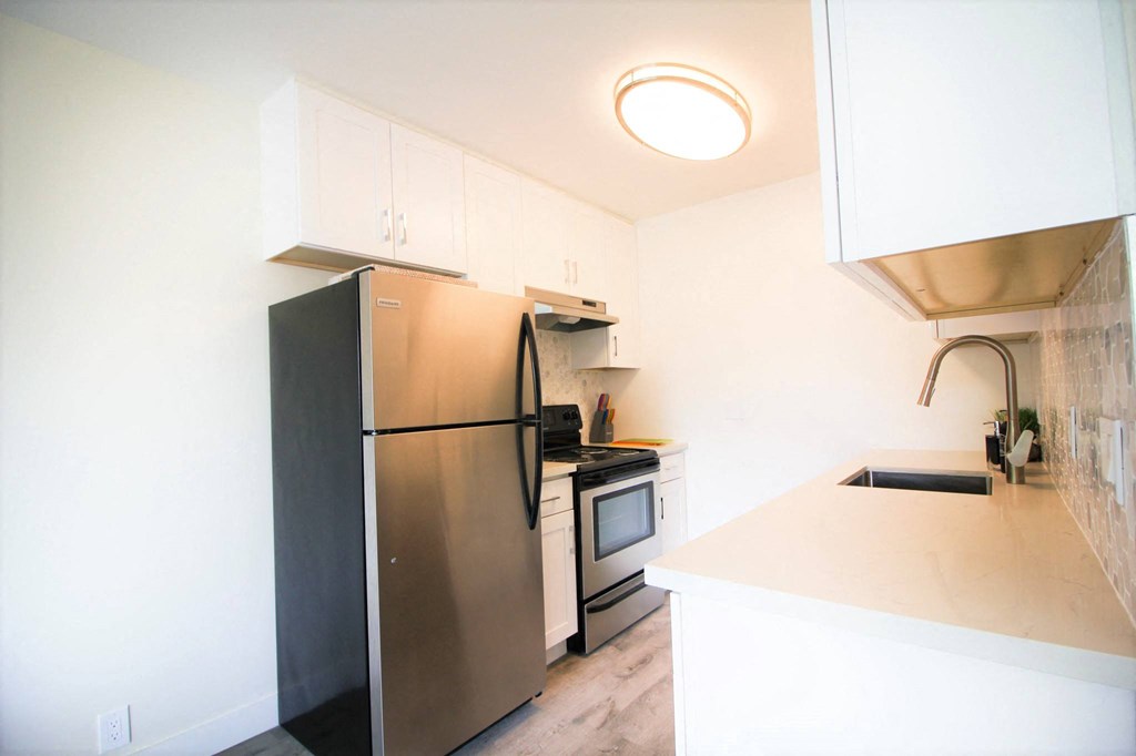 a kitchen with stainless steel appliances and white cabinets