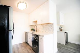 a kitchen with white cabinets and a washing machine