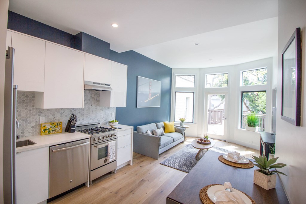 Open-concept living room and kitchen area with upgraded appliances.