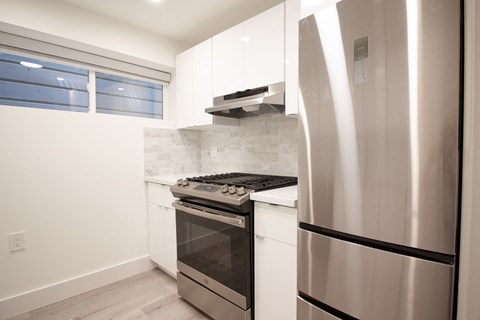a kitchen with stainless steel appliances and white cabinets