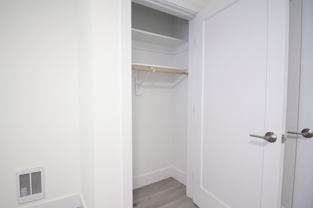 a walk in closet in a small room with a white door