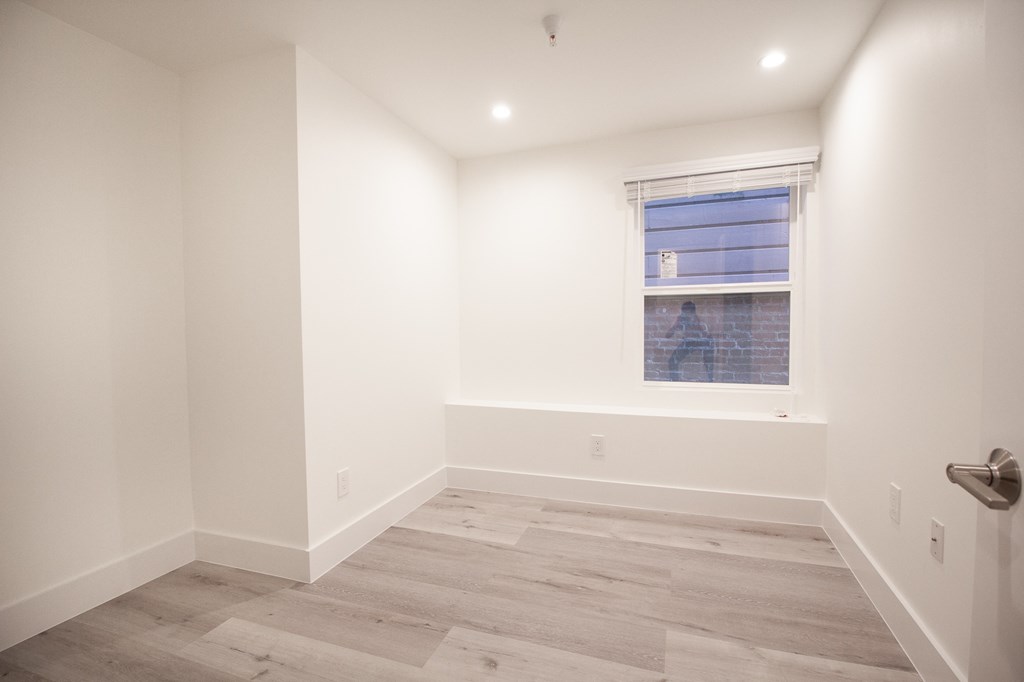 an empty room with white walls and a window