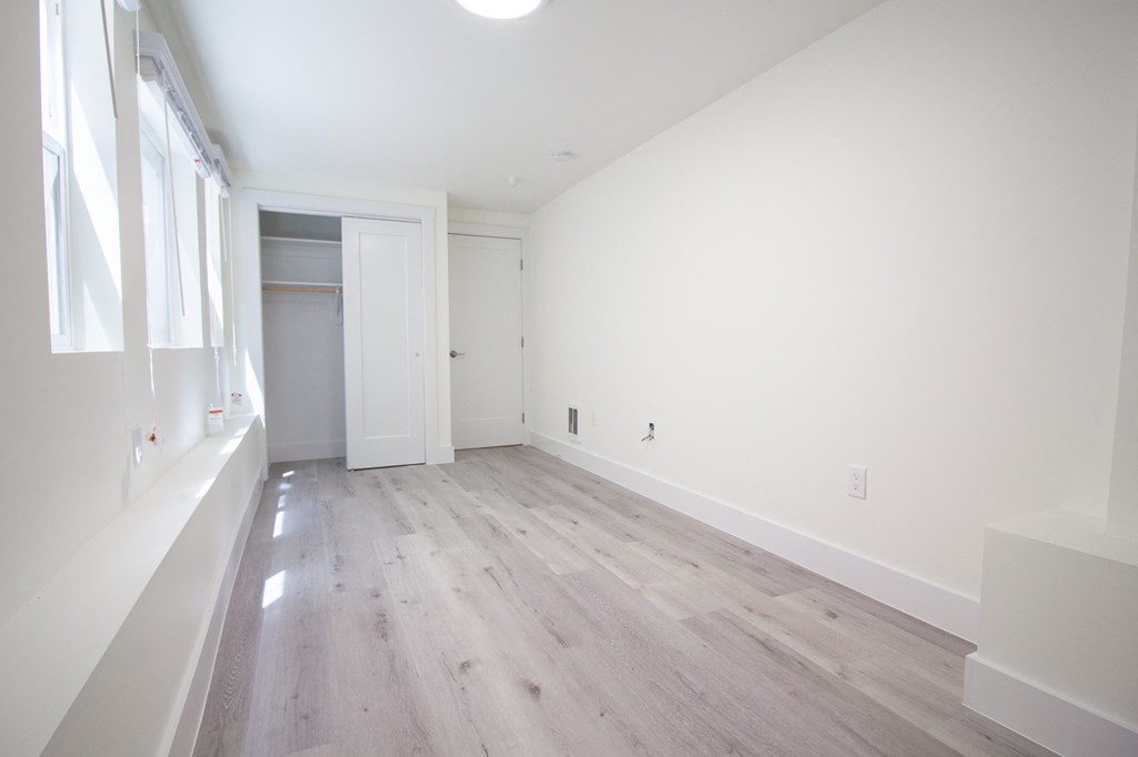 a living room with white walls and wood floors