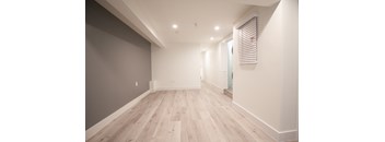 a renovated living room with wood floors and white walls