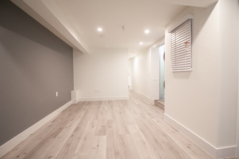 a renovated living room with wood floors and white walls