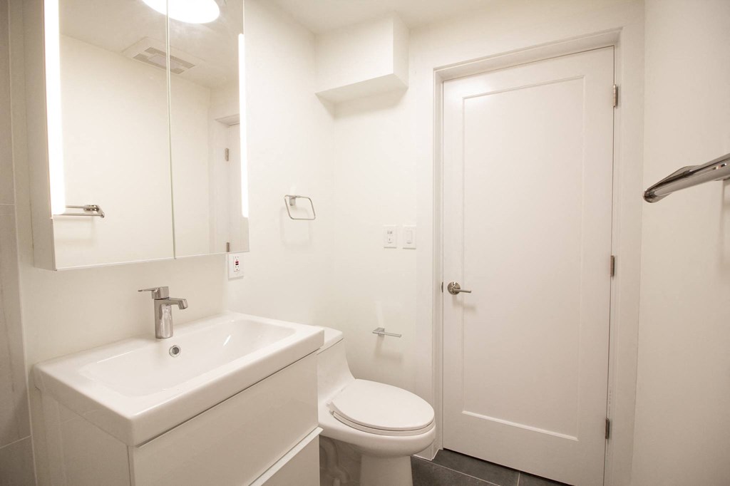 a white bathroom with a sink toilet and shower