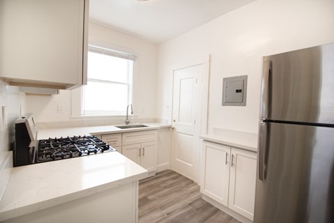 a kitchen with white cabinets and a stainless steel refrigerator