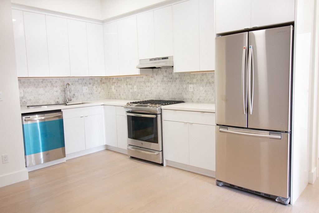 spacious kitchen with stainless steel appliances and white cabinets
