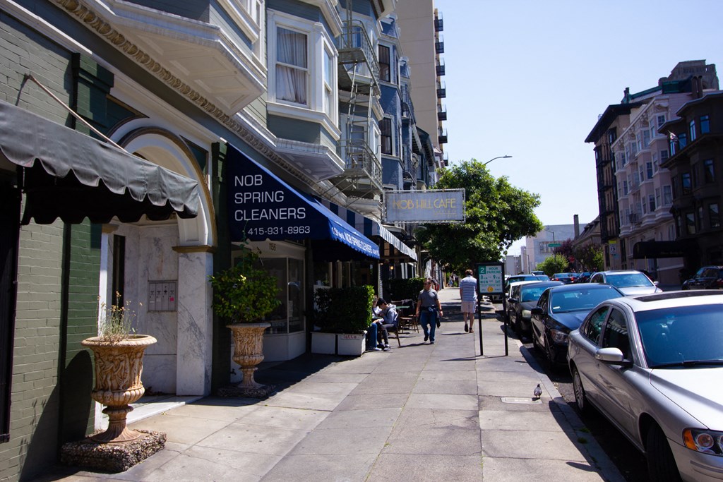the sidewalk in front of the spring cleaners storefront on a busy city street