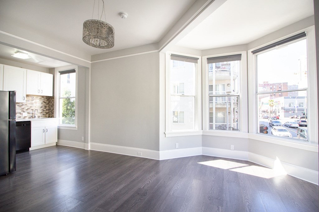 spacious bedroom with hardwood floor and big windows for ample lighting.