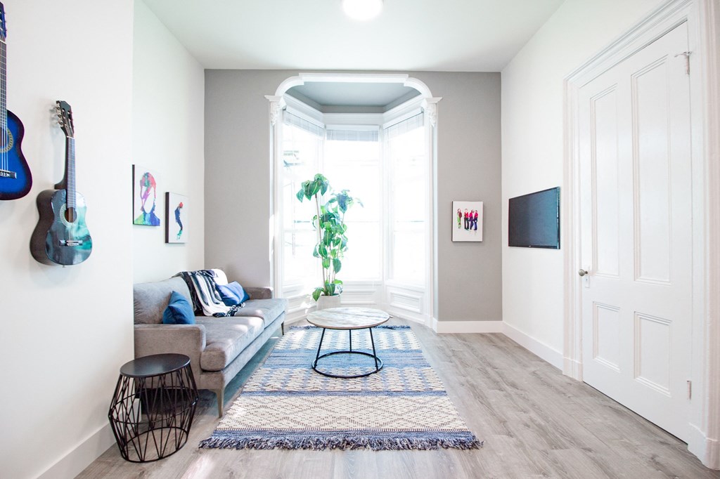 living room area with a couch, a coffee table,  indoor plant and tv