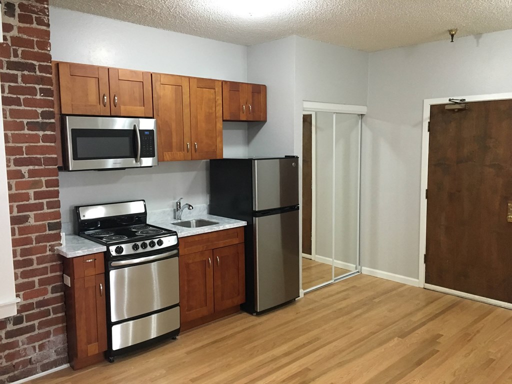 a small kitchen with stainless steel appliances and wooden cabinets