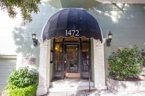 the front door of a building with a black awning