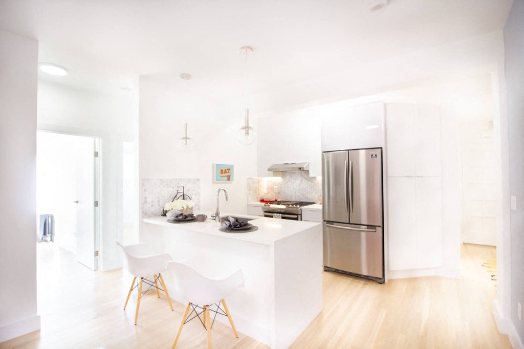 kitchen island with two chairs and stainless steel appliances