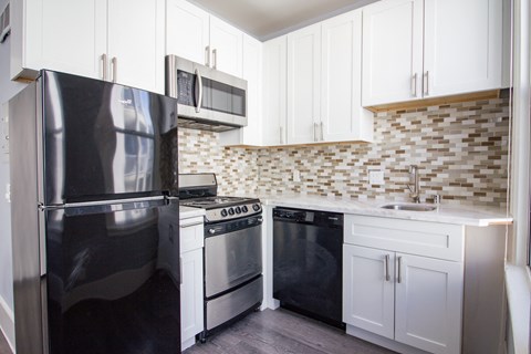 a kitchen with black appliances and white cabinets