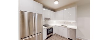 a kitchen with white cabinets and stainless steel appliances